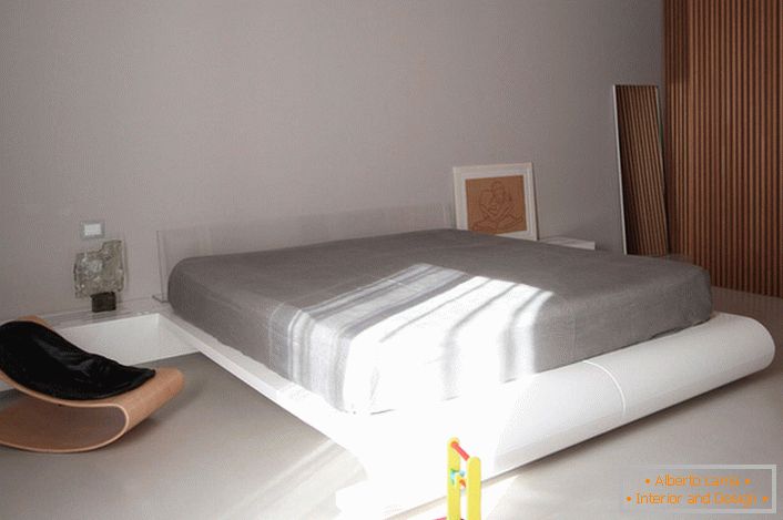 Um quarto de crianças no estilo do minimalismo com uma cama grande é uma solução interessante para uma família com dois filhos.