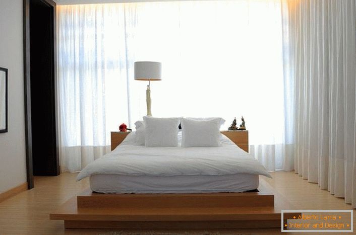 A cama assemelha-se a um grande colchão de penas macio, localizado em uma alta passarela de madeira. Cortinas feitas de tecido macio, translúcido e voador tornam a atmosfera da sala romântica e relaxante. 