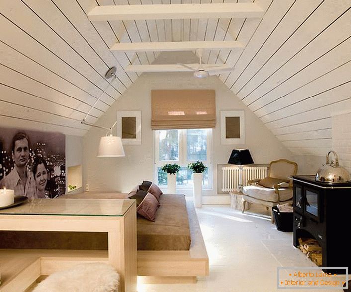 O sótão é decorado em estilo minimalista, com notas de chalé. O espírito do estilo da aldeia torna o quarto especial e memorável.