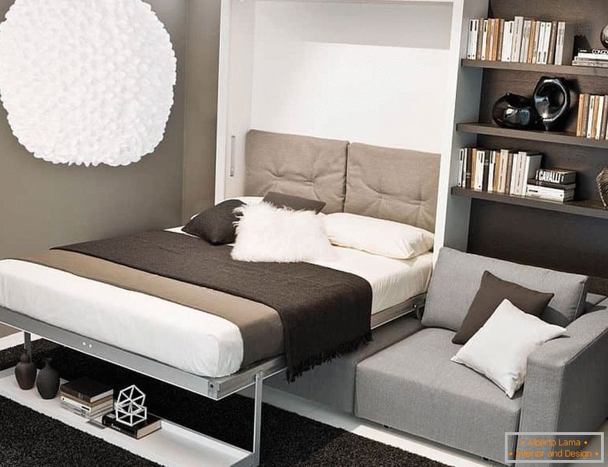 Uma cama escondida em um armário sobre um sofá em uma pequena sala