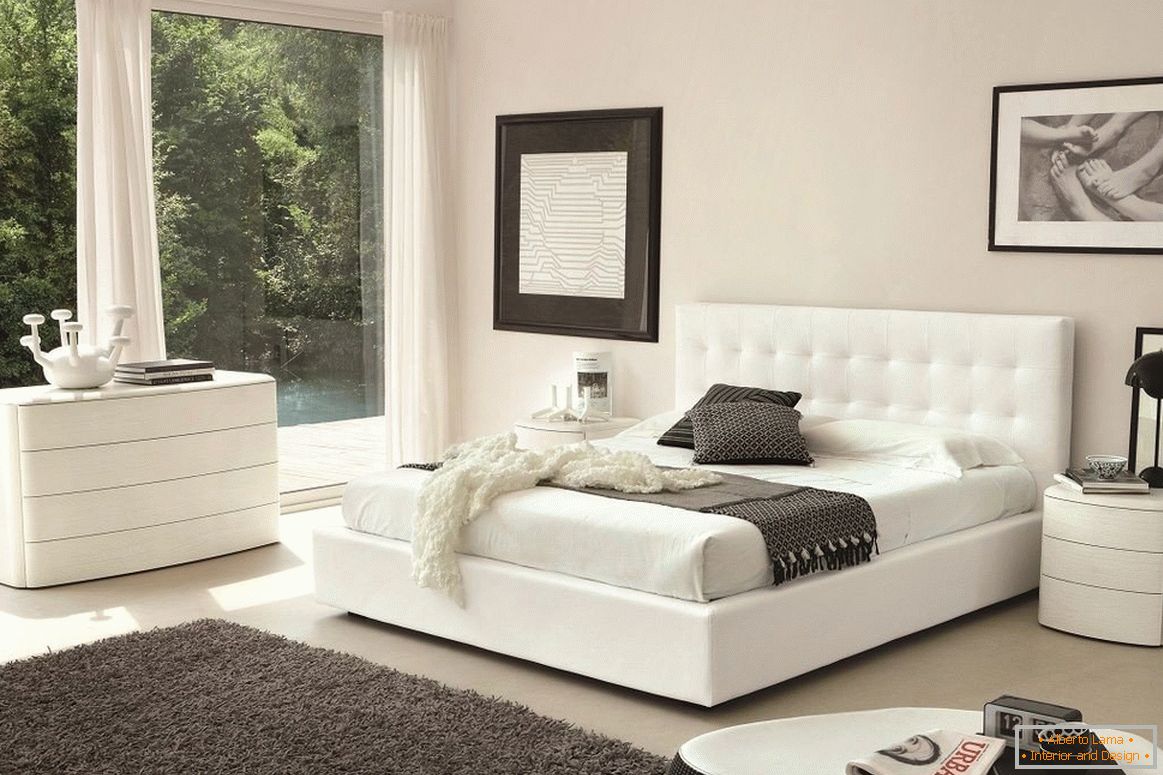 Cama branca, cômoda e mesa de cabeceira no quarto