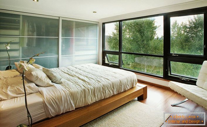 Uma cama baixa feita de madeira se encaixa harmoniosamente no interior do quarto no estilo Art Nouveau.