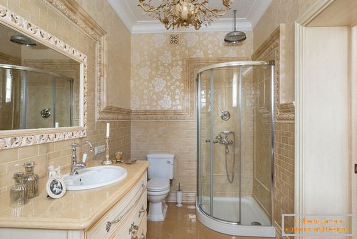 O banheiro é decorado em estilo neoclássico. Um espelho grande, emoldurado por uma moldura ampla, torna a imagem completa.