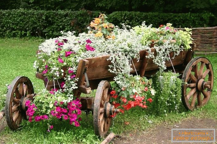 Como utensílios para a criação de um canteiro de flores, foi utilizado um carrinho antigo e restaurado. Uma solução interessante para a decoração do quintal da casa de campo. 