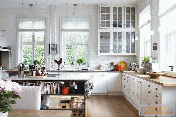 Uma cozinha espaçosa em estilo escandinavo deve ser o mais leve possível. Prioridade é dada à luz do dia, então a cozinha está equipada com grandes janelas com molduras de madeira. 