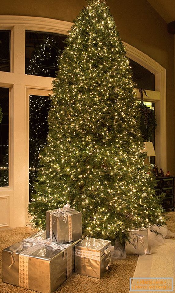 Decoração incomum de uma enorme árvore de Natal com guirlandas
