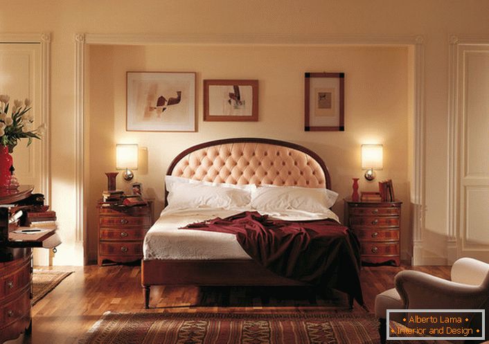 O estilo inglês nobre no quarto é atraente e modesto. O centro das atenções é uma cama em uma cabeceira alta, que é cravejada com um pano bege suave.