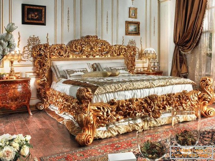 Uma cama luxuosa é feita nas melhores tradições do estilo Império. Massive backs de uma cama de madeira esculpida de cor dourada nobre destacam-se no contexto de outros detalhes interiores.