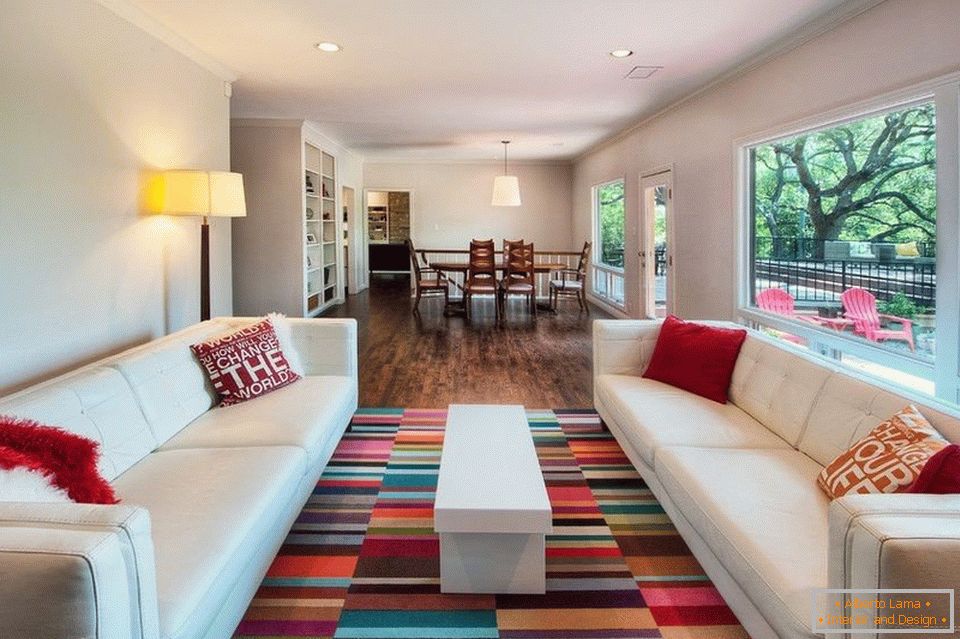 Sala de estar com sofás brancos e tapete colorido
