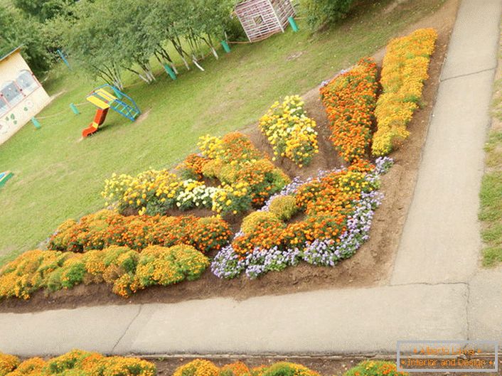 Jardim de flores modular sob a forma de um sol radiante olha harmoniosamente no parque infantil.