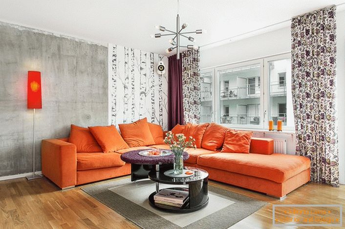 O estilo escandinavo é inerente ao uso de cores quentes no design de interiores. O sofá alaranjado macio olha organically no fundo das paredes de uma matiz frio-cinzenta.