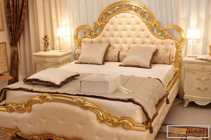 As costas da cama são cobertas com seda macia de cor bege, de acordo com as exigências do estilo barroco.