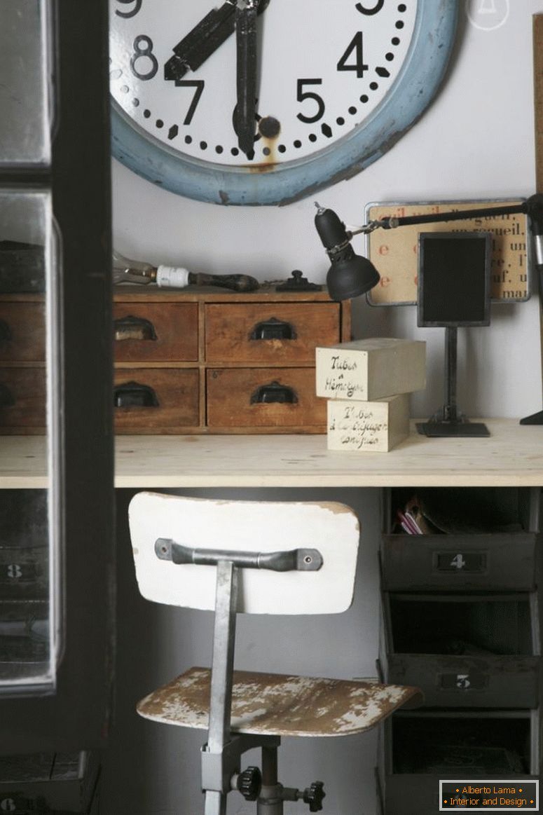 Relógio de estação velha acima de mesa vintage com caixas de organizador de madeira e cadeira giratória de madeira com pintura descascada