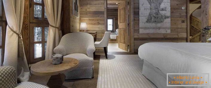 No quarto no estilo do chalé alpino é uma cama que se assemelha a um colchão de penas arejado.