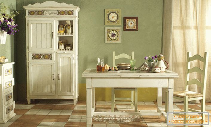 Uma cozinha acolhedora em estilo country é executada em luz branca e suave-oliva. Combinação perfeita de cores para o estilo rústico.