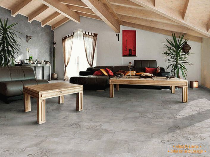 A cobertura de pisos e paredes imita um acabamento áspero. Os tetos de madeira são combinados em uma composição comum com móveis. Uma variação de sorte do estilo loft na sala de estar.