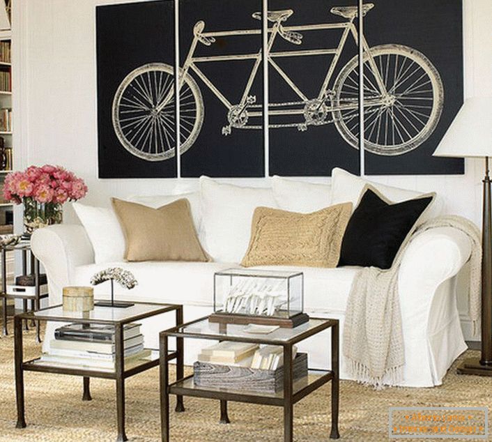 A sala de estar em estilo escandinavo é decorada com pinturas modulares representando uma bicicleta. Não sobrecarregado com significado, o design torna o design completo. 