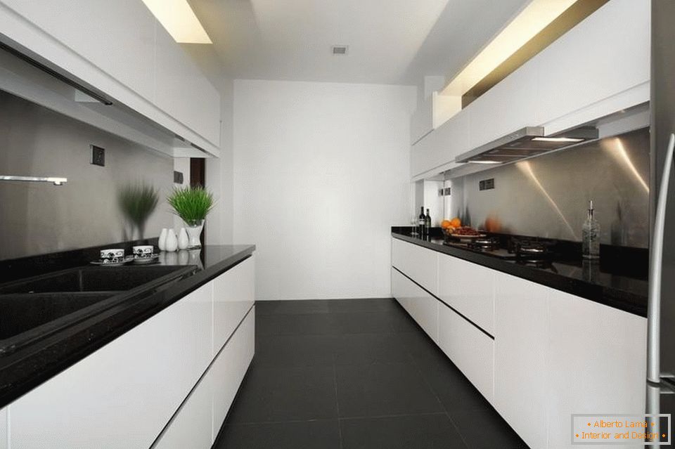 Uma cozinha branca estreita e longa com um piso preto
