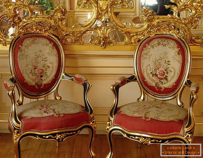 Estuque a céu aberto de cor dourada no espelho e cadeiras com estofamento macio vermelho - representantes brilhantes do estilo barroco.