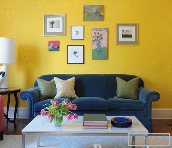 Sofá azul em um fundo de parede amarelo